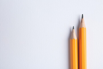 Sharp graphite pencils on light background, top view. Space for text