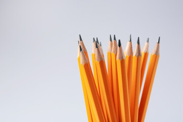 Sharp graphite pencils on light grey background, closeup. Space for text
