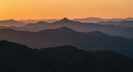 Obraz premium Serene Sunset Over Layered Mountains: A Breathtaking Panorama of Hues and Shadows
