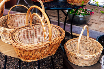 Handmade wicker baskets displayed on a wooden table in a rustic market setting