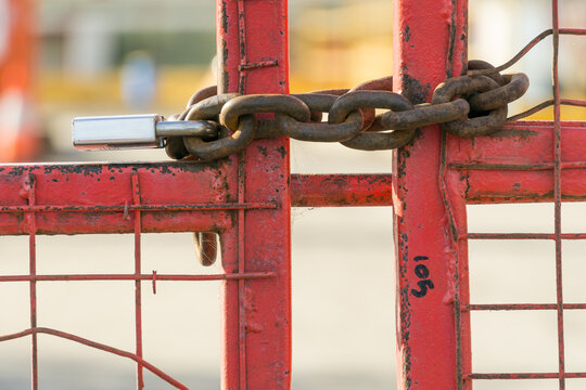 Close up of a paddlock and chains on a locked metal gate