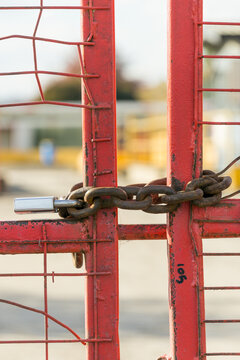 Close up of a padlock and chains on a locked metal gate