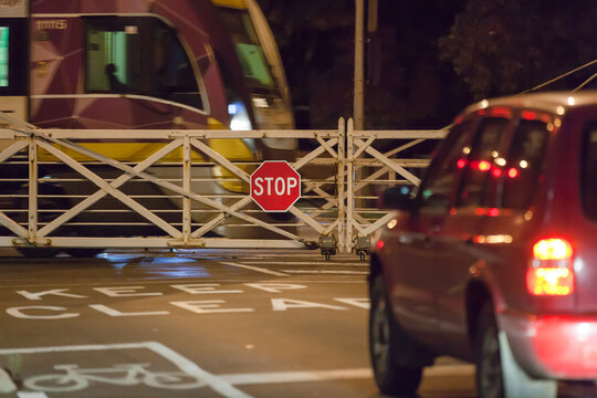 car waiting at rail crossing with train passing through
