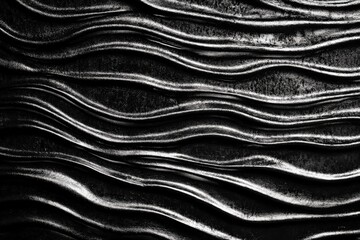 Black and white wavy metallic surface creating an abstract pattern.