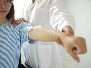 Fototapeta premium Asian female patient doing physical therapy with physiotherapist arm pain treatment in hospital, health concept