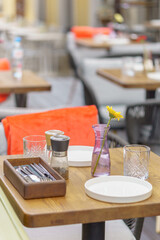 Served tables in a summer street restaurant. Atmosphere of coziness and beauty.