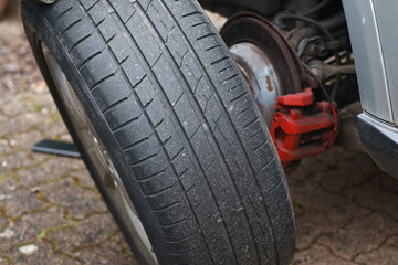 Fototapeta premium Close-up a man changes a wheel in a car on the road.