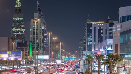 Cityscape aerial night timelapse of Riyadh, Saudi Arabia, featuring illuminated towers, skyscrapers, King Fahd Road and busy traffic. Palms and streetlights line the main highway through the city.