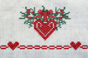 
Cross stitch. Red heart, cross-stitched. Needle and thread. Cross stitch.