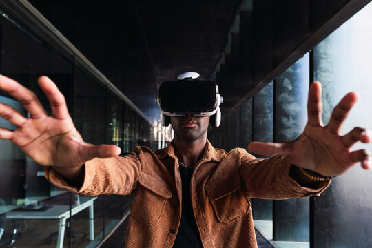 Businessman wearing vr headset interacting with virtual reality in modern office space, exploring metaverse