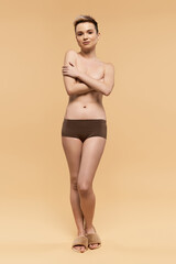 Young woman confidently embracing body positivity in a simple, elegant setting