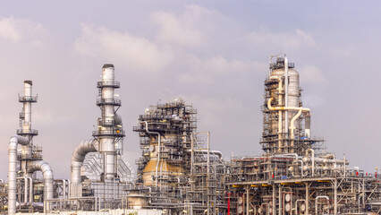 Oil refinery petrochemical plant at dusk illuminated storage tank industrial infrastructure, Oil...