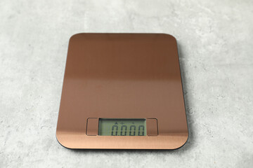 Modern electronic kitchen scale on grey table, closeup