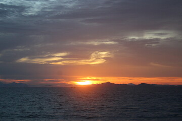 Colorful sunrise seascape. The sky ablaze with hues of orange and pink reflecting on the serene water