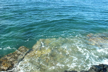 Crystal-clear ocean. Sunlight illuminates the pristine waters near a rocky shore. Perfect for nature and calming visuals