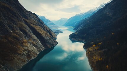Aerial view of a diverse landscape featuring a winding river flowing through a mix of green and autumn-colored trees.