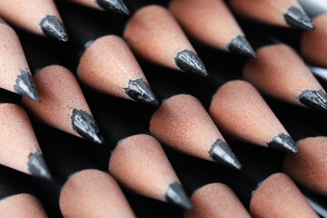 Many sharp graphite pencil on white background, closeup