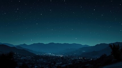 Night cityscape nestled among dark, silhouetted mountains.