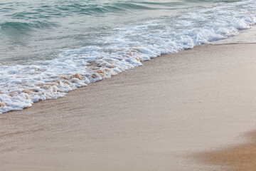 The ocean waves are crashing onto the shore, creating a peaceful