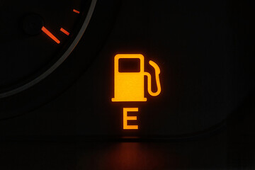 Fuel gauge warning light indicating low fuel level in vehicle  