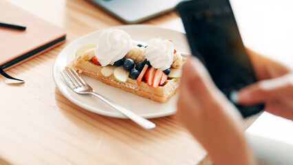 Cafe, photo and person with waffle with phone for social media, internet and influencer post. Restaurant, coffee shop and hands with smartphone for picture of sweet treat, dessert and breakfast