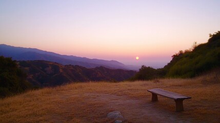 Serene sunset view from a mountaintop, overlooking a valley with a wooden bench in the foreground