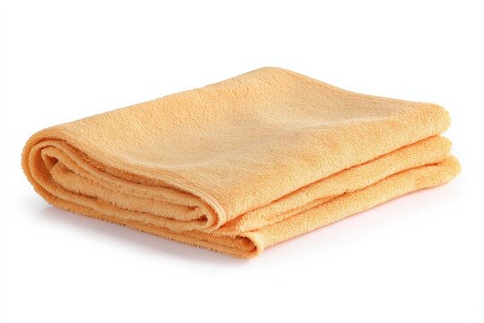 Soft, pale orange towel folded neatly on a white background. Perfect for adding a touch of warmth and comfort to your photos.