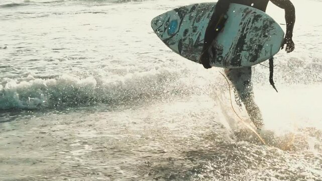 African surfer's ocean dive: slow motion entry into Cap Skirring sea, golden hour swimming with surfboard, Casamance coastline
