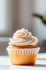 A single, vanilla cupcake with creamy frosting sits on a white surface, bathed in soft sunlight
