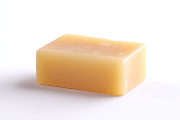 A pale yellow bar of soap sits on a white background.  The soap is rectangular and has a slightly textured surface.