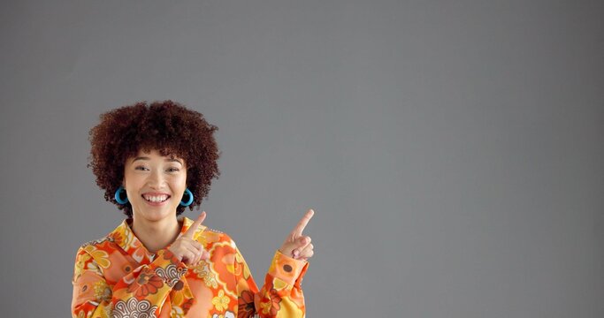 Woman, portrait and pointing up in studio for fashion announcement, notice or info with retro style promo. Ads, mockup or space for news, afro person or vintage clothes coming soon on gray background