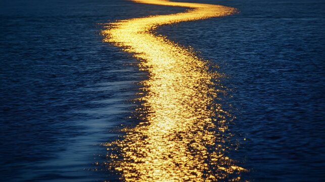 Sunrise casting a golden path on a perfectly flat sea with minimalist tones