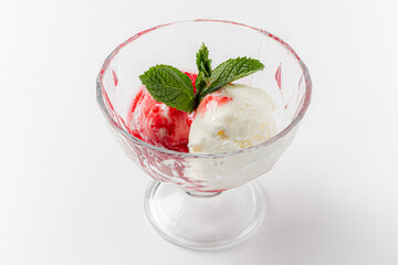 A vibrant bowl holds strawberry and vanilla ice cream, topped with mint