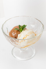 Indulgent two-scoop dessert features rich chocolate and creamy vanilla flavors, garnished with mint