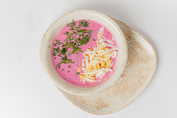 Bright beetroot soup topped with fresh herbs and cabbage adds a delightful touch