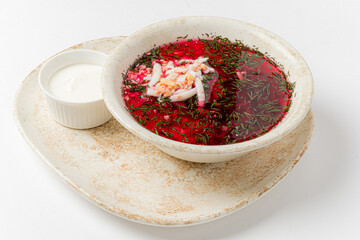 Refreshing chilled beet soup features crab and vibrant herbs, paired with a rich creamy sauce