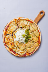 Delight in a pizza featuring grilled eggplant, creamy sauce, and fresh herbs, beautifully presented