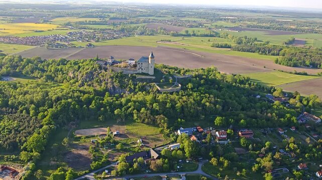 Aerial panoramic view of Kuneticka Hora Castle in Central Bohemia, surrounded by spring landscape and farmlands.