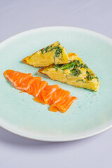 A vibrant omelette with herbs and fresh salmon slices makes a culinary delight