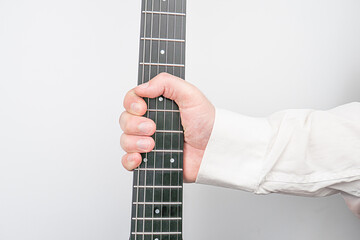 Close-up image of a hand playing an acoustic guitar, featuring the fretboard and strings Even...