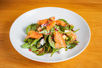 Vibrant salad with fresh spinach, smoked salmon, and creamy dressing, beautifully arranged