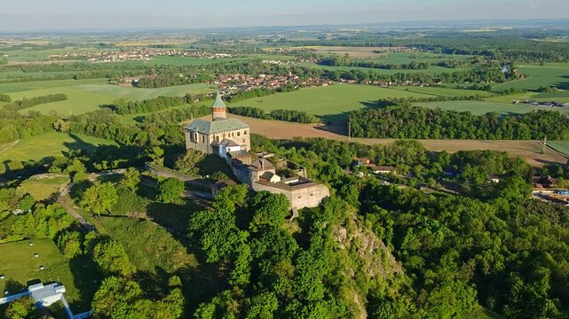 Aerial panoramic view of Kuneticka Hora Castle in Central Bohemia, surrounded by spring landscape and farmlands.