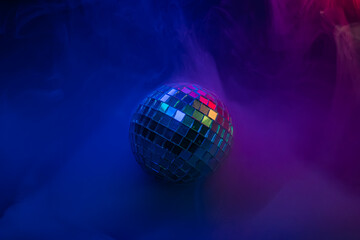 A vibrant, energetic image showcasing a disco ball amidst swirling smoke in a festive color scheme pink, purple, blue Ideal for marketing materials related to events, parties, or retro vibes