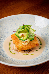 A crispy fillet with cucumbers and herbs, served deliciously on sauce