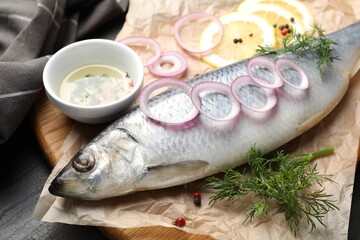Tasty herring with spices on black table, closeup