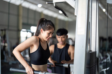 Fototapeta premium Wellness and Strength Training. Woman exercising with personal trainer in gym.