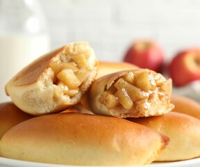 Tasty baked patties with apples on table, closeup