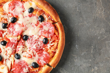 Tasty pizza with salami, cheese and olives on grey table, top view. Space for text