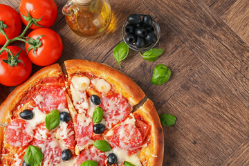 Tasty pizza and ingredients on wooden table, flat lay. Space for text