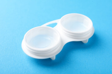 Contact lenses in case on light blue background, closeup